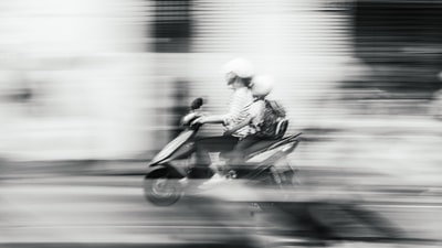 女人和孩子超速驾驶摩托车在路上
